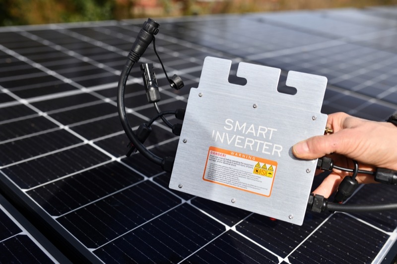 hand grabs smart micro inverter in front of photovoltaic system. Beautiful banner with blurred background