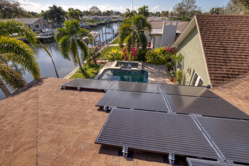 Solar panels on a roof in Florida with view of a pool and a canal