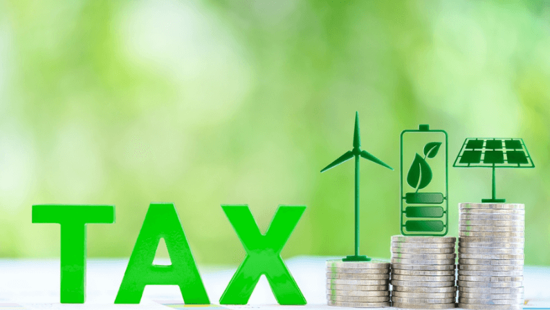 Clean, renewable energy or electricity production tax credits and incentives, financial concept : Green energy symbols atop coin stack e.g solar panel, wind turbine, fuel cell battery and the word TAX.